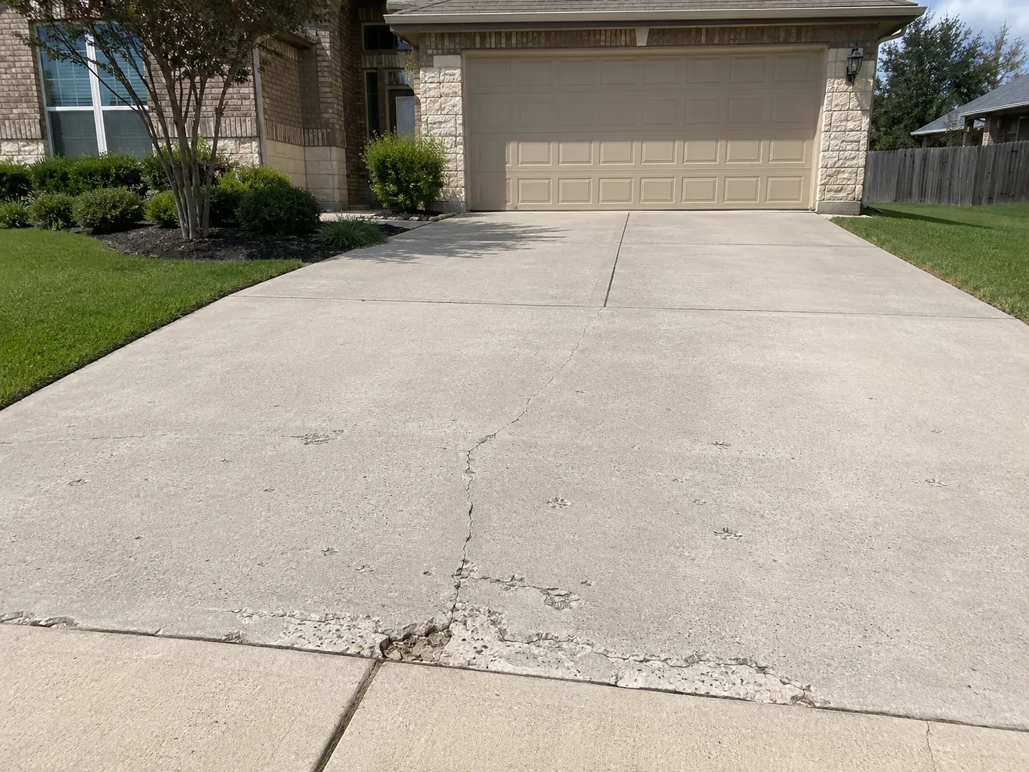 Damaged concrete driveway before repair