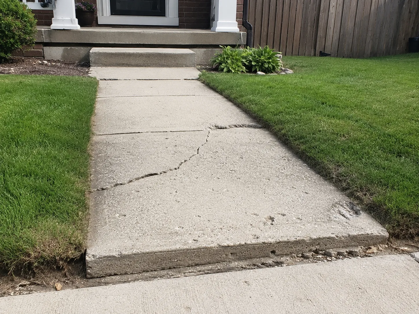 Damaged concrete walkway before repair